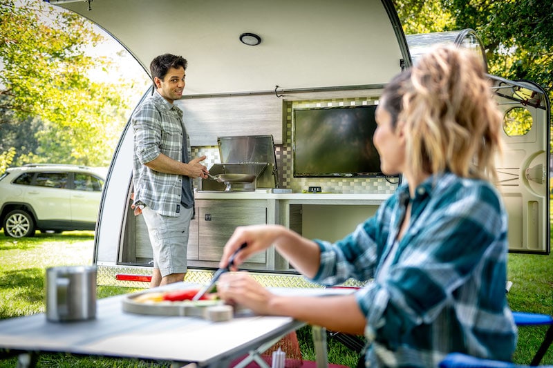 guy cooking on outdoor rear camper kitchen