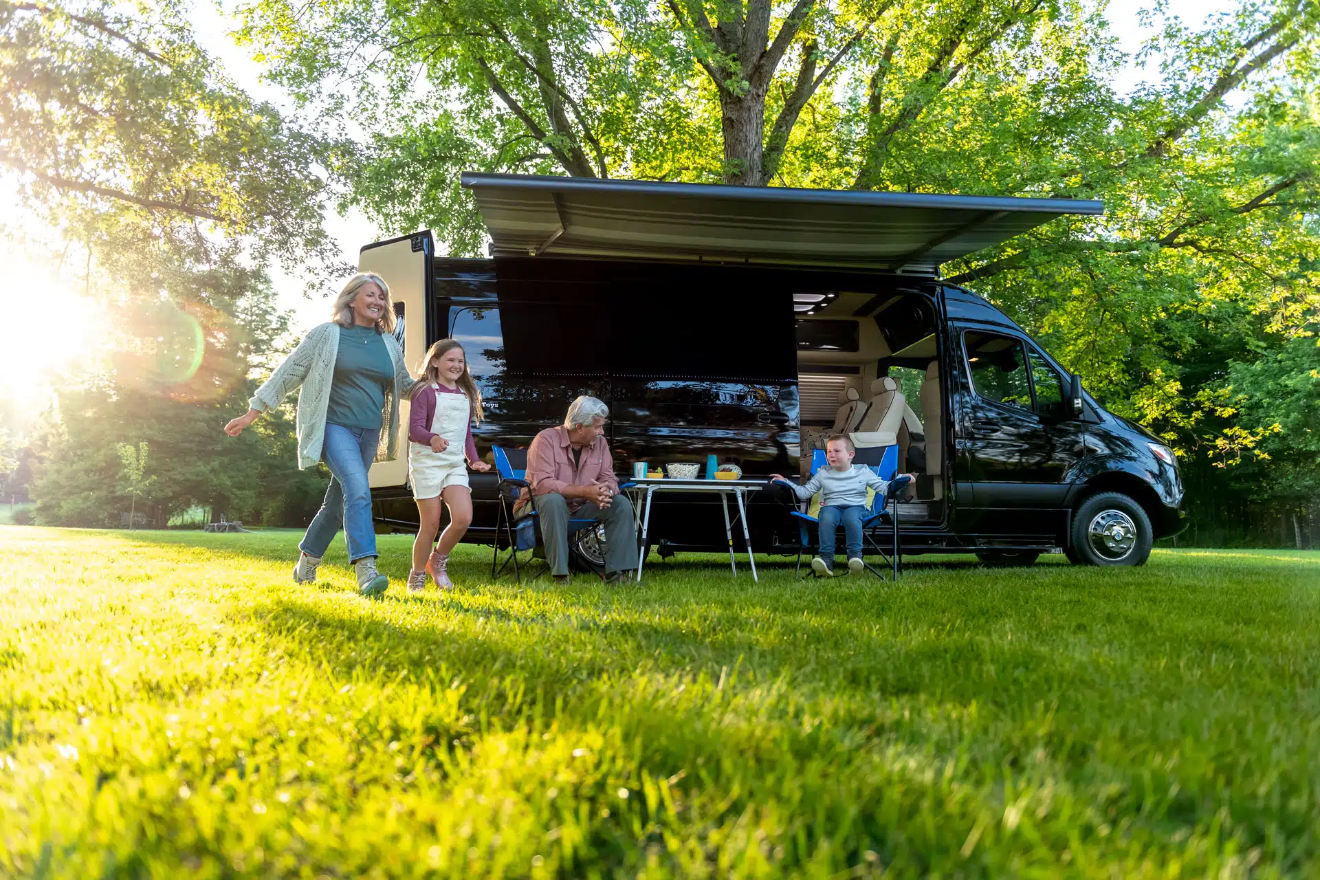 Our Mercedes Sprinter camper van showing a happy family enjoying the great outdoors.